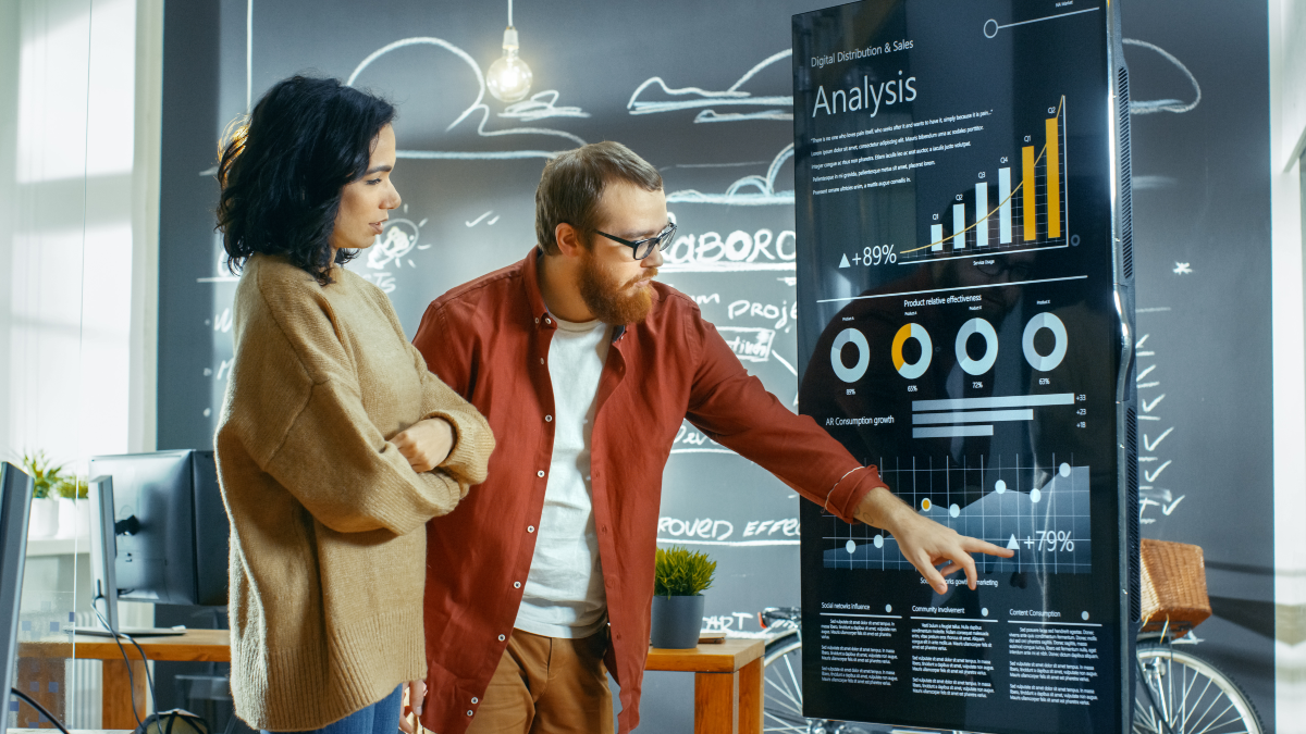 man and woman looking at large graph of a business analysis and stats - business valuation